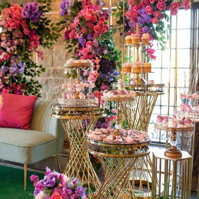 An elegantly decorated dessert and seating area featuring lush floral arrangements.