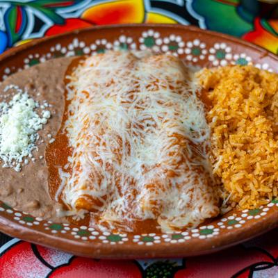 Enchiladas covered in red sauce and cheese, served alongside rice and refried beans.