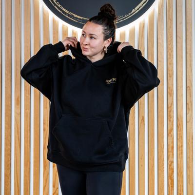 Woman in an black ''Hula Pot'' hoodie, front view, closeup.