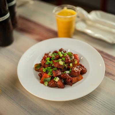 Chili chicken topped with chopped scallions, served with a cup of mango lassi.
