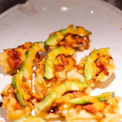Crispy bites topped with avocado and savory sauce.