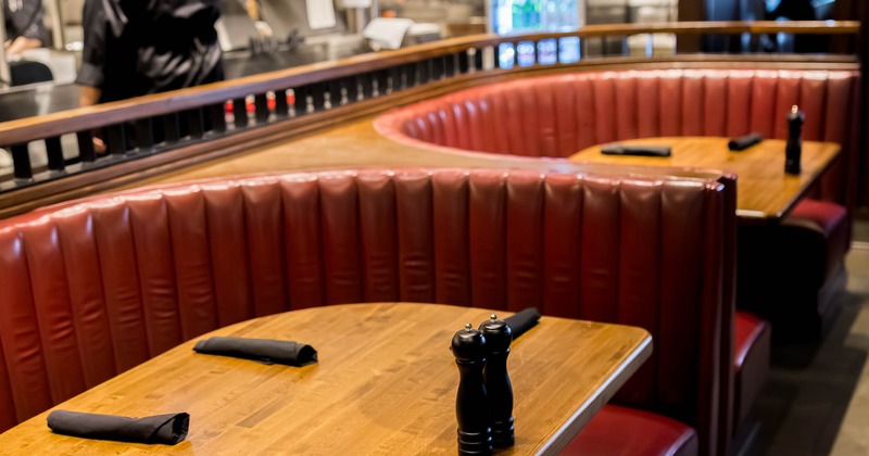 Restaurant interior with red booths and wooden tables