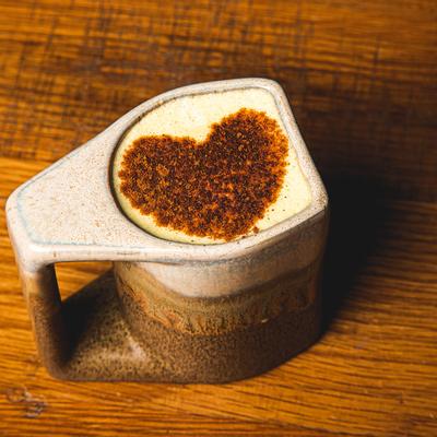 Mug of cappuccino, heart decoration on top.