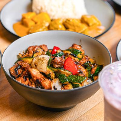 Rice bowl with stir fried chicken and veggies.