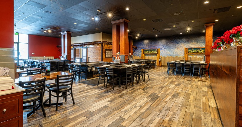 Interior seating area with wooden floors, black tables and chairs