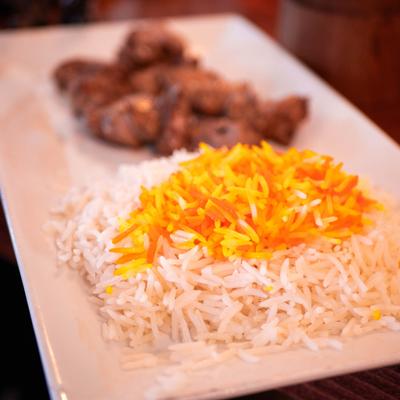 Basmati saffron rice with meat in the background.