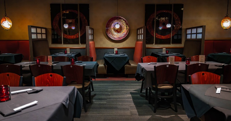 Dimly lit restaurant with tables, booths and decorative art.