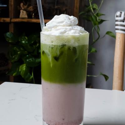 Iced strawberry matcha topped with whipped cream.