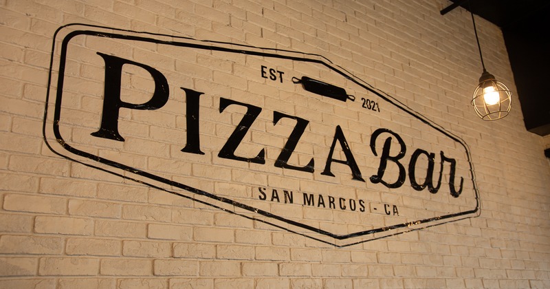 Interior, brick wall painted in white with a large Restaurant logo