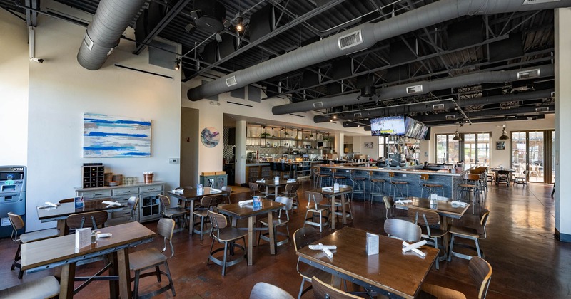Interior, tables and chairs, bar and kitchen in the back, waiter serving station