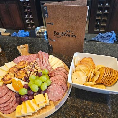 Charcuterie board, served on the bar with a menu.