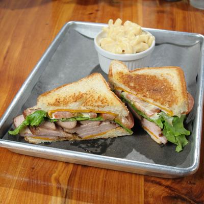 Smoked turkey sandwich served mac and cheese.