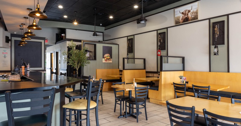 Interior seating area with wooden chairs, tables and booths