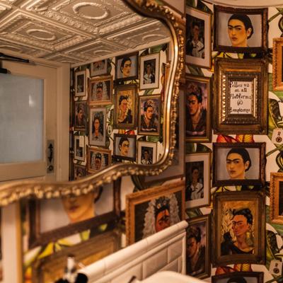 Large mirror, various framed portraits of Frida Kahlo.