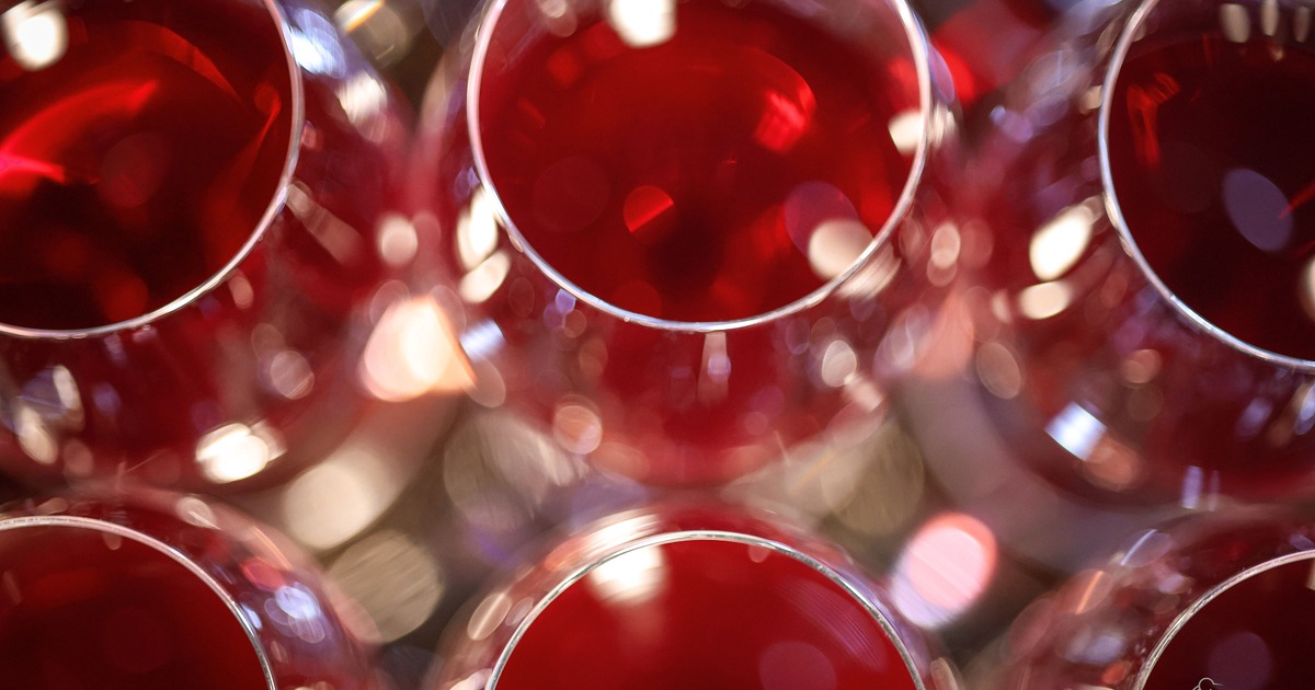 Close-up of multiple red wine glasses with reflections