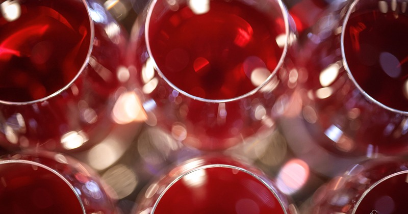 Close-up of multiple red wine glasses with reflections