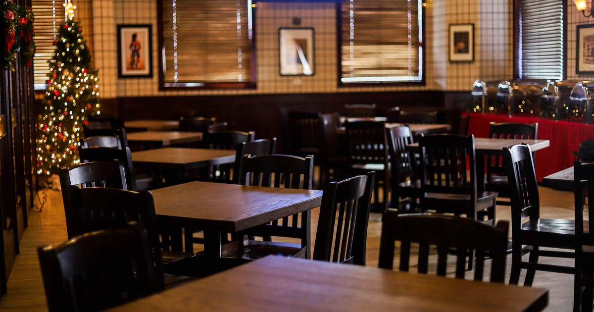 Dining room with wooden tables, chairs, and wall art