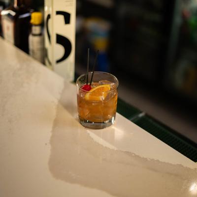 Old Fashioned cocktail served on a bar counter.