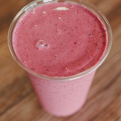 Mixed berry smoothie in a plastic cup.