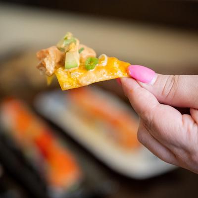 A nacho bite in hand, close up.