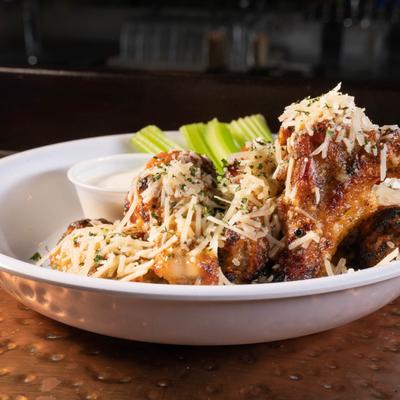 Fried chicken wings, covered in garlic parmesan, with celery and ranch dressing