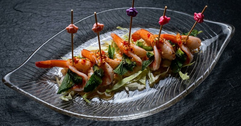 Shrimp roe skewers served on a glass plate with greens