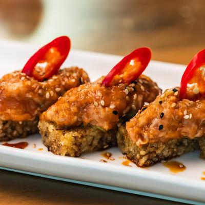 Salmon Crispy Rice topped with sliced red chilies and sesame seeds.