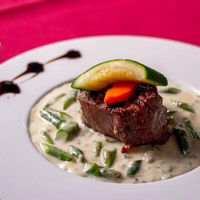 Steak with white sauce with vegetables.