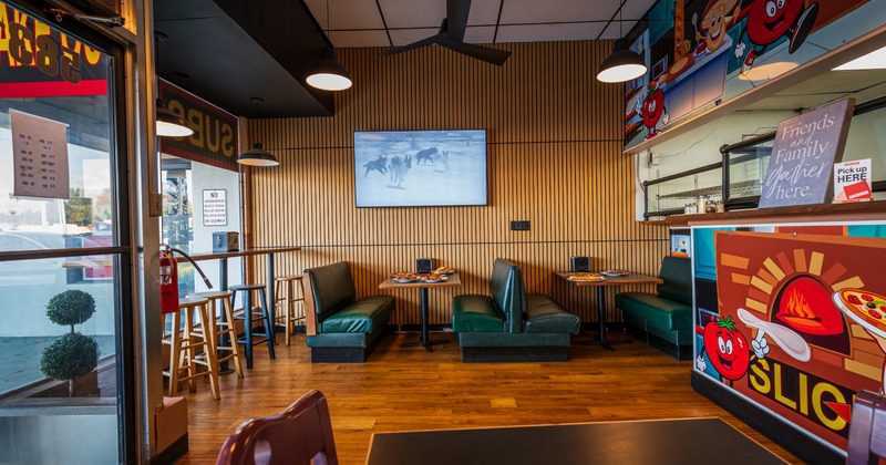 Dining area with booths, tables and bar chairs by the window