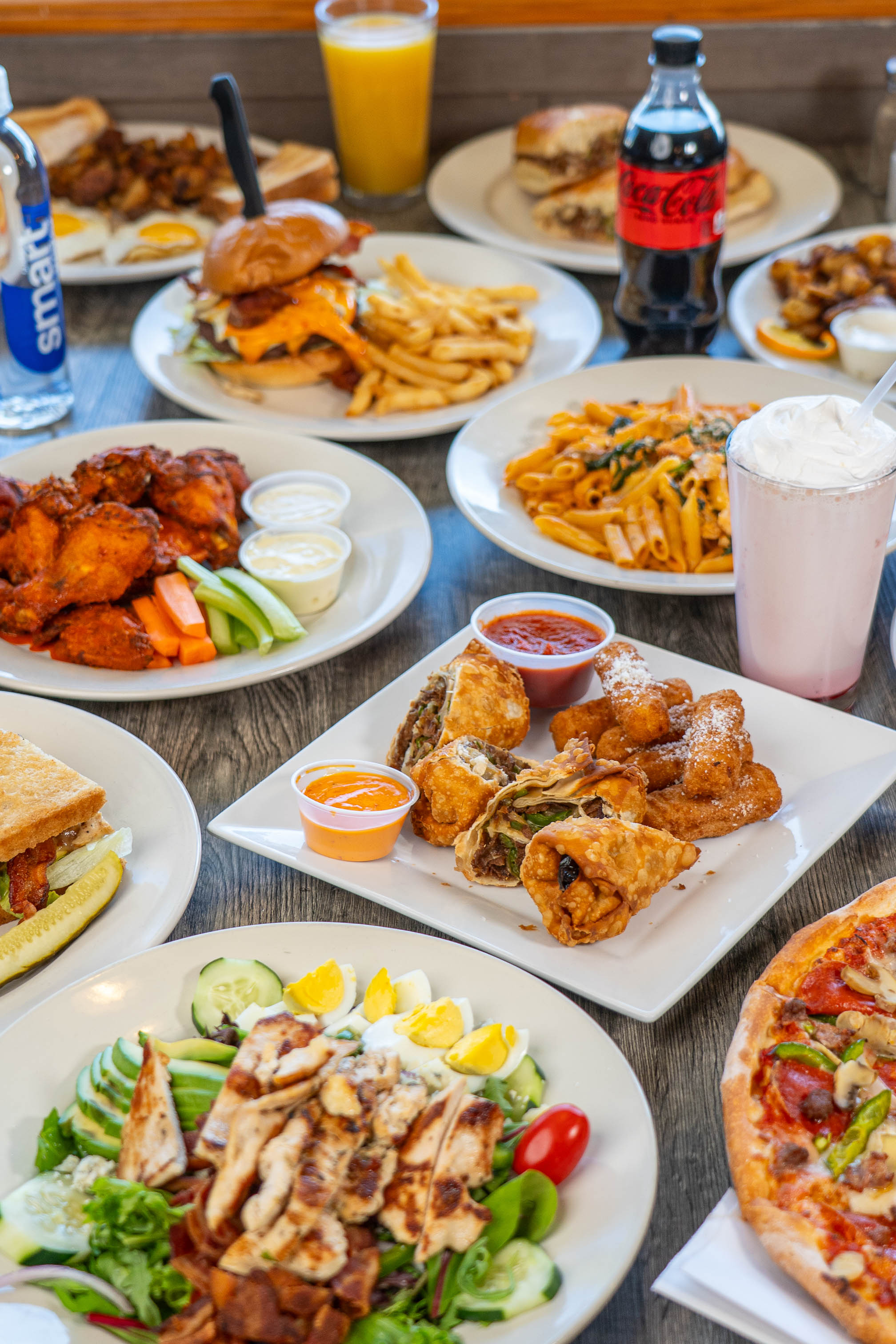 Assortment of dishes and drinks from Granby's Pizzeria, displayed on a table