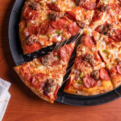 Atlas Combo Pizza with one slice seperated from the pie.