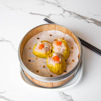 Shrimp and pork shumai served in a traditional bamboo steamer basket.