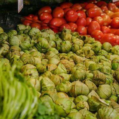 Tomatillos and red tomatoes displayed in a store.