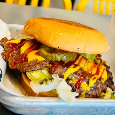 Cheeseburger with lettuce, ketchup, mustard, and pickles.