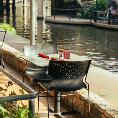 Small outdoor table for two people by a water canal.
