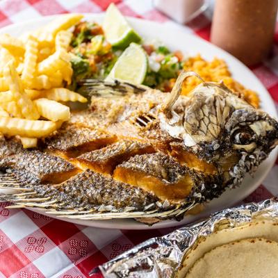 Fried whole fish with fries and rice.