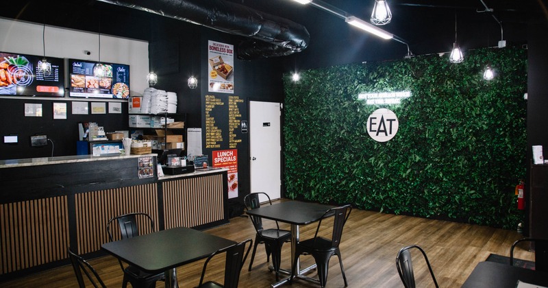 Interior of a modern dining area with a service counter, green leaf wall