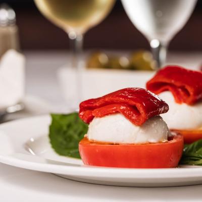 Appetizer with mozzarella, roasted red pepper, and tomato slice.