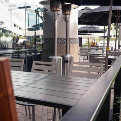 Outdoor seating area, tables, chairs, and parasols.