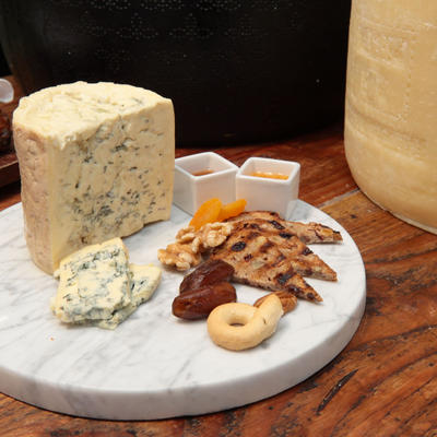 Cheese served with bread, walnuts, toast, and condiments