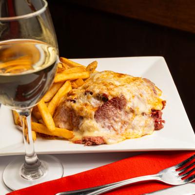 Reuben sandwich with fries and a glass of white wine