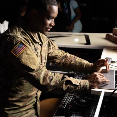 Person with laptop and DJ equipment.