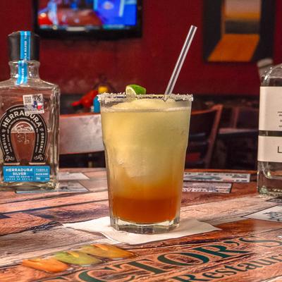 Frozen Magarita with salt rim and lime wedge garnish.