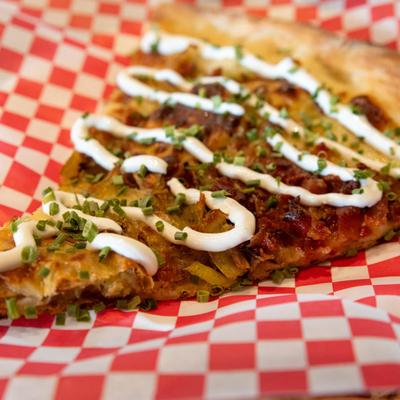 Loaded & Baked pizza slice, close up.