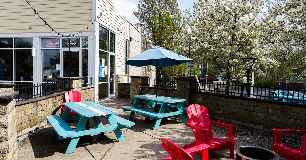 Patio, wooden tables with benches and one parasol