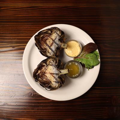Grilled Artichoke cut in half with butter and chipotle mayo.