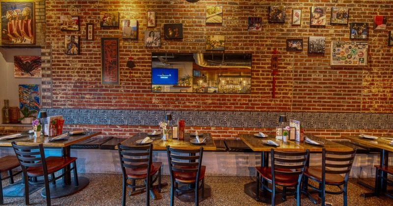 Interior, tables set for guests near wall with pictures