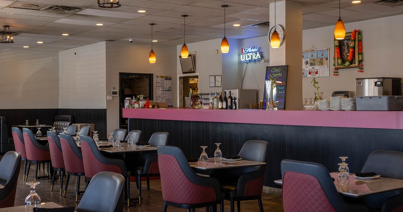 Interior, tables and chairs in dining area near bar