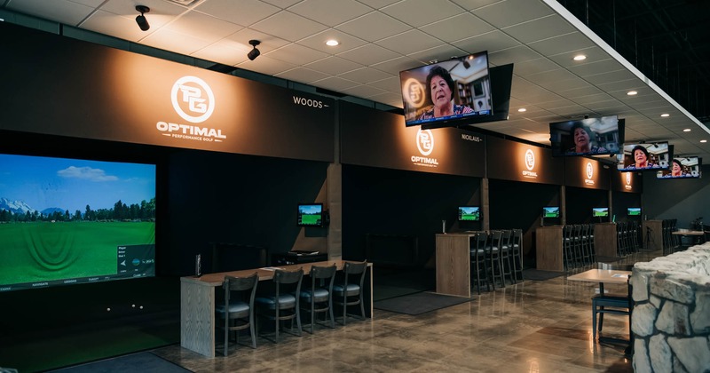 Booths with big led screens above the mini golf digital terrain, bar tables and chairs
