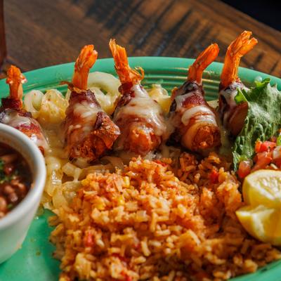 Shrimp wrapped in bacon, served with rice and garlic butter sauce